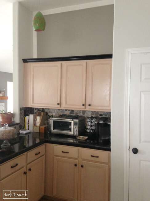 Stuck with pickled oak cabinets?? Make them seem a little less "pink" by painting walls with a cool gray color! www.tableandhearth.com