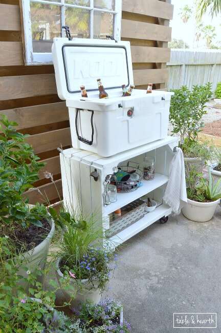 Awesome bar cart and cooler stand for entertaining! Table & Hearth completely transformed this boring, bare, and beat up patio space into a relaxed, neutral, and weathered coastal-meets-farmhouse space! Great DIYs and curated decor make it such a beautiful space.