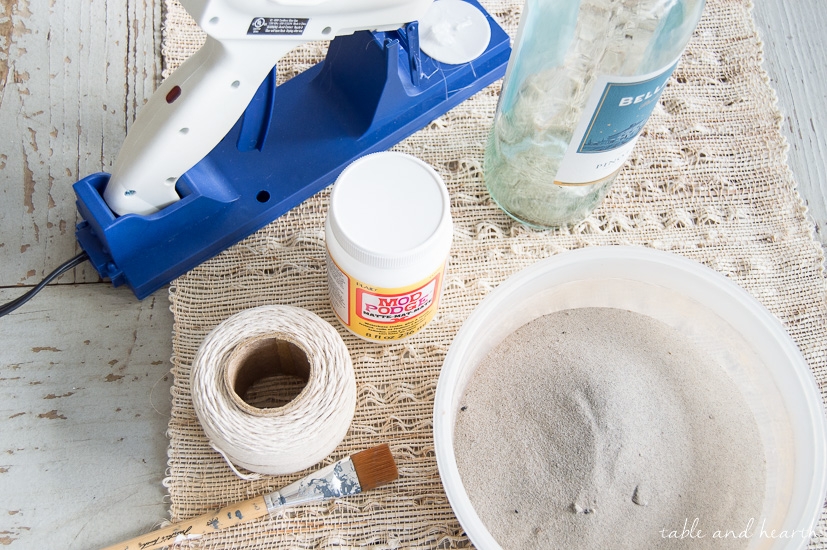 Who knew you could Mod Podge sand?! These beachy sand covered bottles are quick and easy to make with just some sand, Mod Podge, and empty bottles!