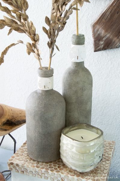 Who knew you could Mod Podge sand?! These beachy sand covered bottles are quick and easy to make with just some sand, Mod Podge, and empty bottles!
